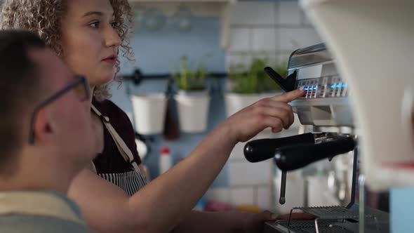 Caucasian man with down syndrome helping waitress in making coffee. Shot with RED helium camera in 8 alt