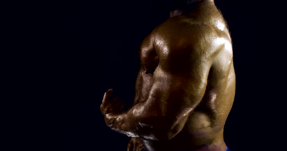 Close-up Portrait of a Male Naked Body of a Bodybuilder, He Is in the Studio on a Black Background alt
