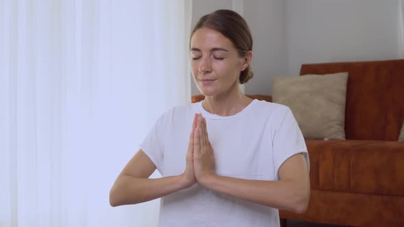 A Woman Does the Practice of Breathing From Yoga and Palm Meditation in Namaste