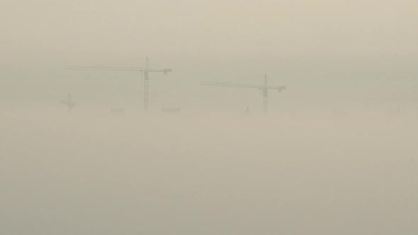 Aerial View. A Construction Cranes In The Fog On The Building Construction alt