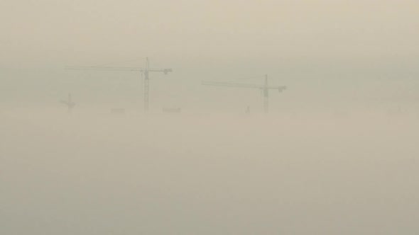 Aerial View. A Construction Cranes In The Fog On The Building Construction