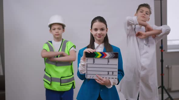 Talented Teenage Girl Clicking Clapper Board Smiling Looking at Camera As Boys in Doctor and Builder alt