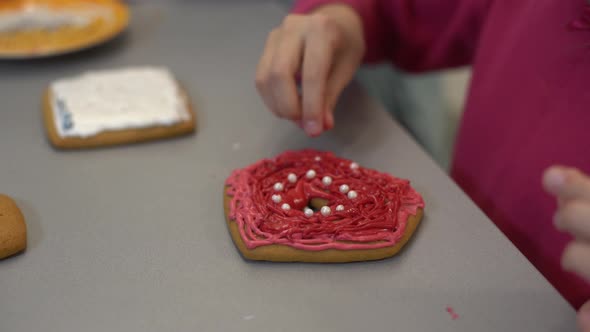 Close Up View of Kids Hands Decorating Homemade Cookies for Holidays