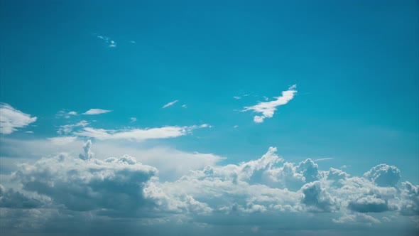 White Fluffy Clouds Slowly Float Through the Blue Daytime Sky Timelapse alt
