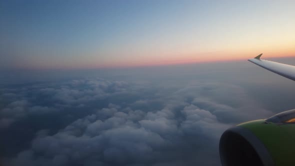 View of an Airplane Wing and Clouds in Flight