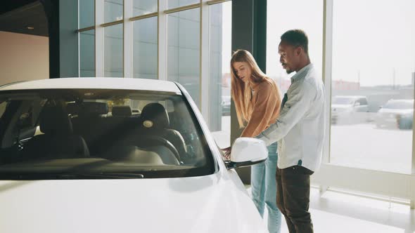 African American Man and Caucasian Woman While Walking at Modern Auto Center alt