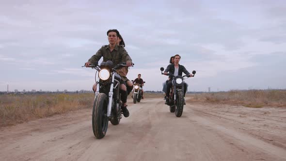 Group of Young People Riding Motorbikes on the Beach in Evening alt