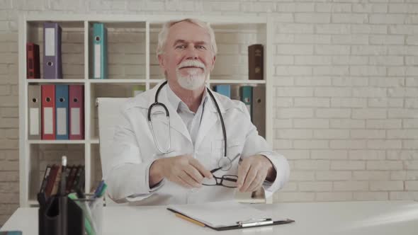 Head Shot Portrait Mature Doctor Wearing Glasses with Arms Crossed in Office, Confident Serious alt