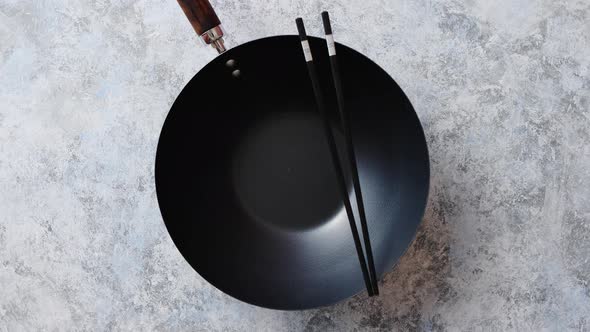 Traditional Empty Black Iron Wok Pan Placed on Stone Background alt