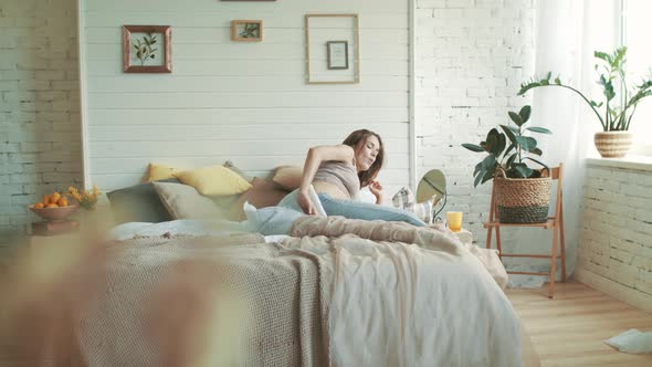 Happy Pregnant Woman Getting Up in Bedroom. Belly Mother Stroking Belly at Home. alt