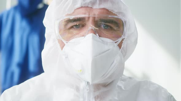 Closeup of Overworked Doctor or Researcher Dressed in Protective Suit Ppe Mask in Laboratory in alt