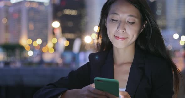 Business Woman Reading on Mobile Phone at Night  alt
