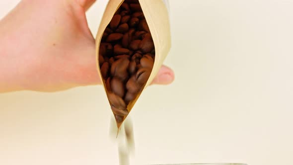 Coffee beans pouring from kraft paper pouch bag on light background cafe 4K Freshly roasted grains alt
