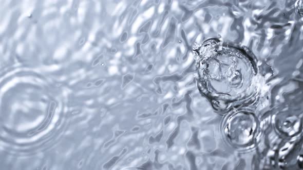 Super Slow Motion Top Shot of Water Drops Falling Into Water Surface at 1000Fps alt