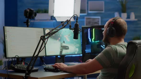 Concentrated Streamer Playing Space Shooter Videogame Using Headset alt