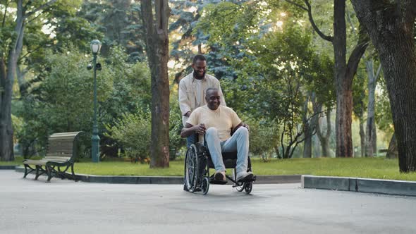 Cheerful Young Black Guy Visits Brother in Hospital Postop Walks Has Fun in Park with Relative or alt