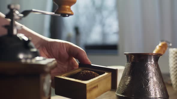 The Process of Grinding Coffee Beans in a Retro Mill alt
