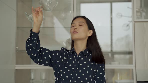 Woman Takes a Glass Out of the Dishwasher While Standing in the Kitchen alt