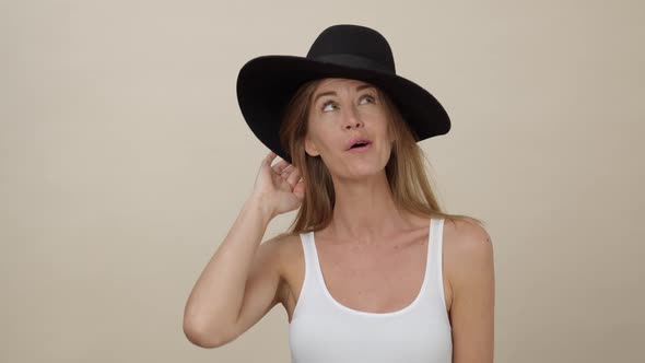 Woman Giggling while Wearing Black Sun Hat