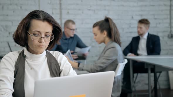 Mature Woman Using Laptop and Working in Office