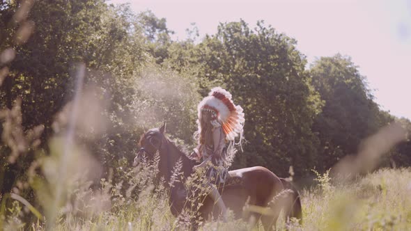 Girl In Native American Headdress On Horseback In Meadow alt
