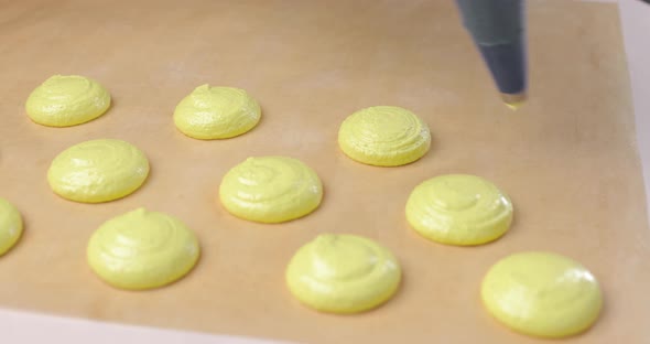 A Pastry Chef Pours Dough or Cream From a Pastry Bag to Make Candies Sweets or Macaroons