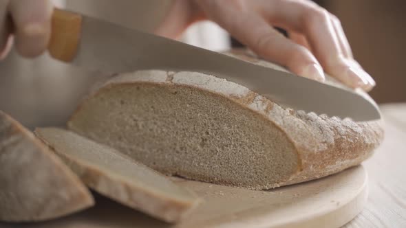 A Woman Baker is Cutting Rye Bread Made From the Highest Grade of Wheat