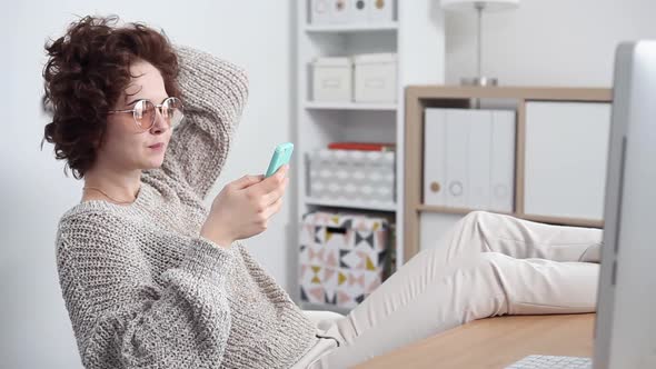 Young Woman Procrastinates Scrolling her Smartphone