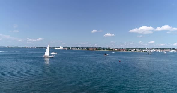 A sailboat catches the summer breeze near Newport Rhode Island in this 4k 60fps drone shot. alt