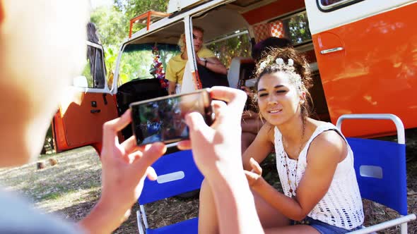Man clicking photo of woman while having bottle of beer in park 4k alt