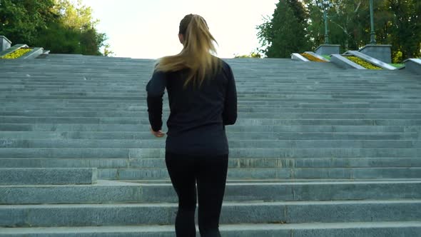 Fit Woman Jogging on Staircase in City alt