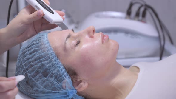 Cosmetologist Using Ultrasonic Scrubber on Clients Face