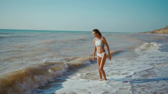 Happy Carefree Slender Woman with Beautiful Fitbody Running Along Seashore of Sea with Waves After alt