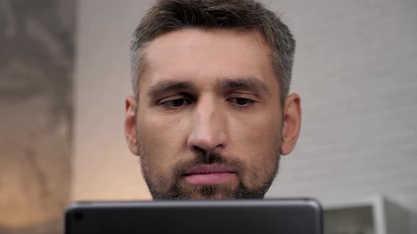 Close Up Face Head Businessman Uses Tablet Sitting on Couch at Home Office alt