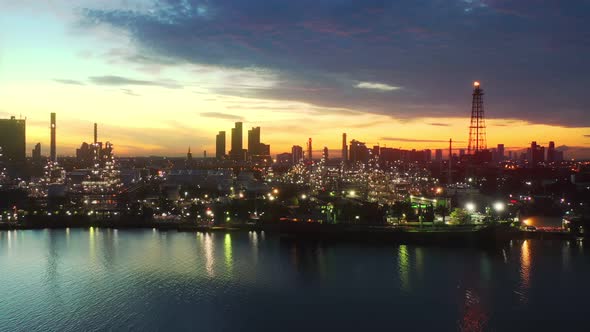 4k aerial view drone of refinery oil petroleum production factory with river reflecting surface sunr alt