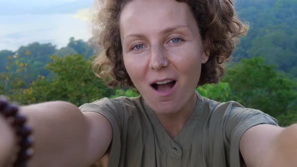 Selfie Shot of Young Beautiful Caucasian Woman Holding Camera Laughing Talking and Showing the View alt