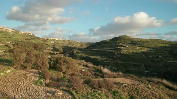 AERIAL: Flying Above Farmland in Malta with Sun Setting During Golden Hour alt