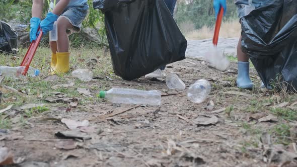 Group of Asian volunteer families collecting garbage and plastic by the river. alt