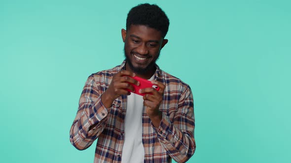 Worried Funny Addicted African American Man Playing Drive Racing Video Games on Mobile Phone alt