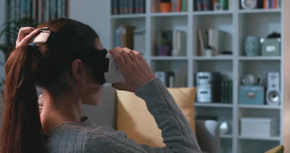 Woman sitting on the couch and experiencing virtual reality