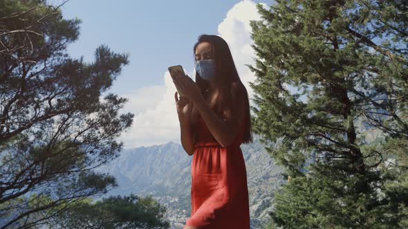 Pretty Woman Using Phone in Forest Wear Protective Face Mask Covid alt