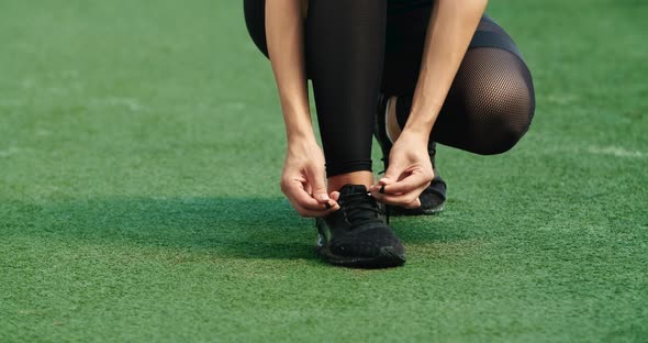 Female Jogger Tying a Shoelace