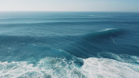 Crushing waves at sunny day; blue water, thick seafoam, natural abstract pattern, sea texture alt