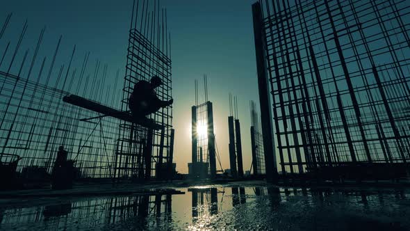 Rooftops at Sunset with a Worker Constructing a Framework alt