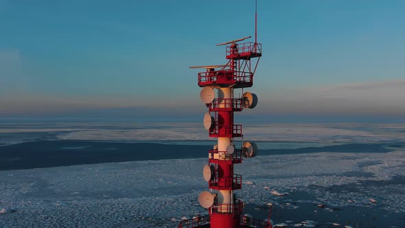 Upper Part of Navigation Tower Against Frozen Sea at Sunset alt
