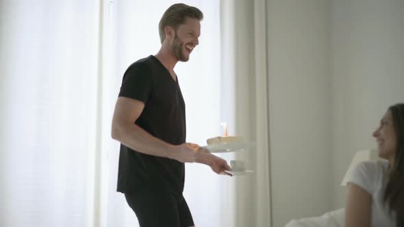 Young Man Bringing Birthday Cake in Bedroom