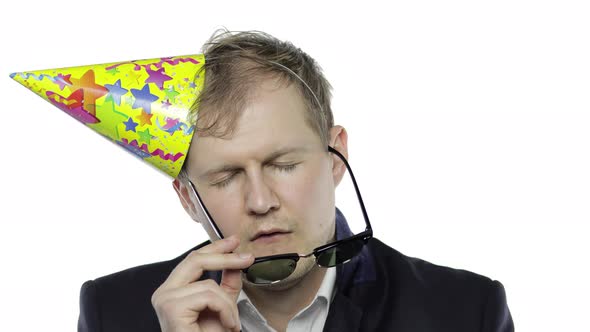 Drunk Sleepy Young Businessman with Hangover in Festive Cap and Sunglasses alt