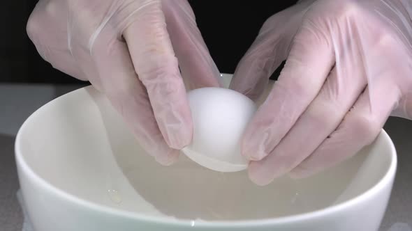 Cracking of Egg on the Bowl with the Hand Gloves
