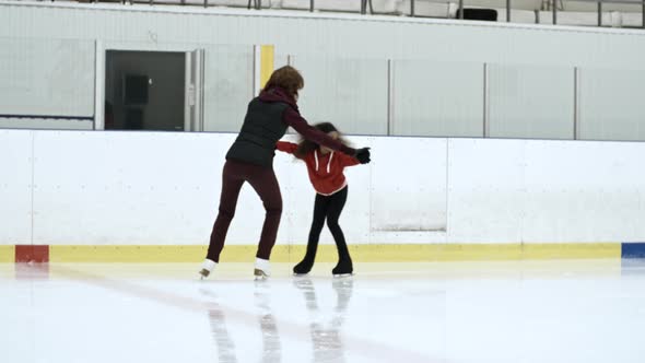 Personal Coach Exercising With Little Figure Skater alt