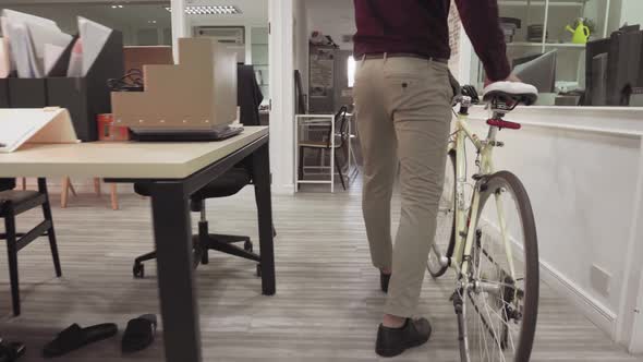 Businessman Arriving At Work Pushing Bicycle